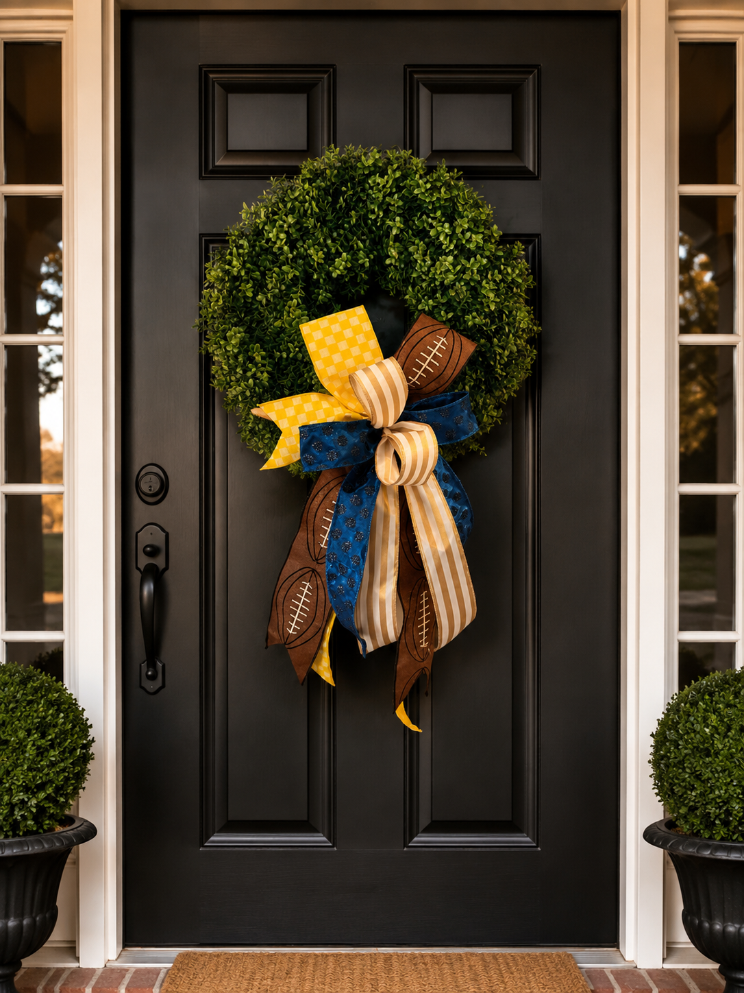 The Golden Wave bow with yellow gingham, gold stripe, navy glitter, and football ribbon on a boxwood wreath